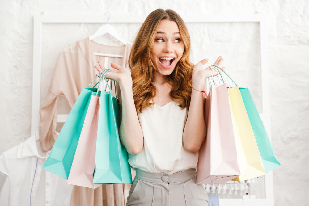 happy-woman-holding-pastel-color-shopping-bags